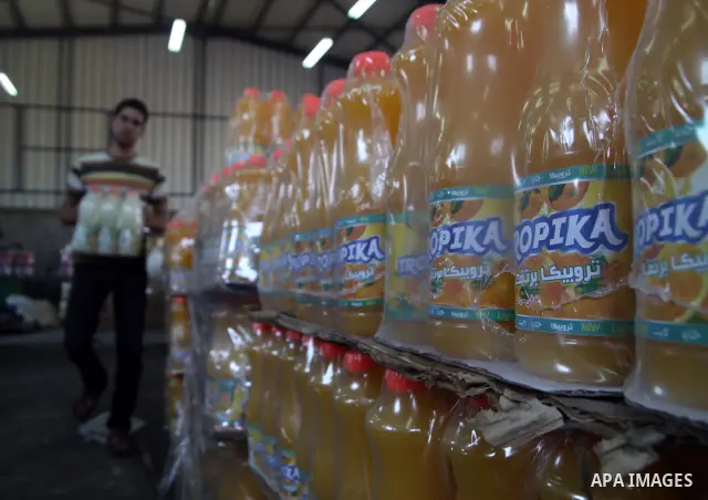 Palestinian workers bottle fruit juice at Juice Factory in Gaza City on Jun 16, 2011. it depends on citrus and fruit that are widely planted in Gaza Strip. Due to the closure of Gaza Strip crossings and the Israeli banni...