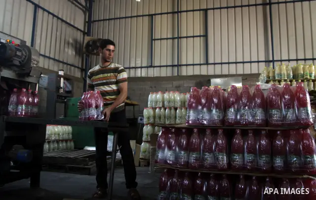 Palestinian workers bottle fruit juice at Juice Factory in Gaza City on Jun 16, 2011. it depends on citrus and fruit that are widely planted in Gaza Strip. Due to the closure of Gaza Strip crossings and the Israeli banni...