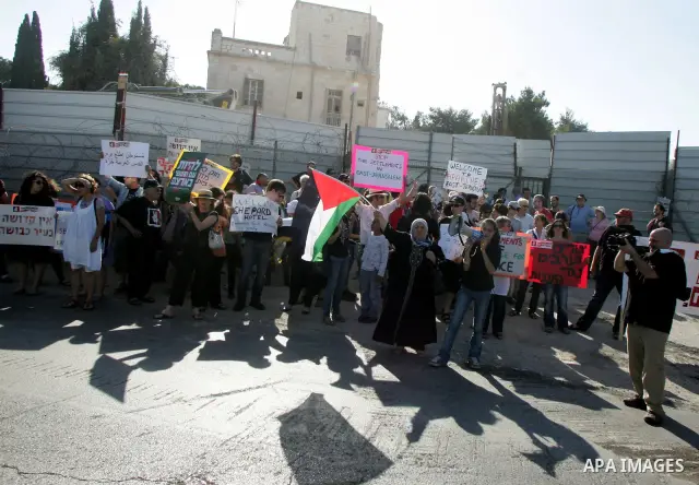 Palestinian demonstrators wave their national flag in the mostly Arab Jerusalem neighbourhood of Sheikh Jarrah on Jun 17, 2011 during a weekly demonstration by Israeli, Palestinian and international activists. Photo by M...