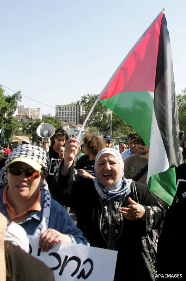 Palestinian demonstrators wave their national flag in the mostly Arab Jerusalem neighbourhood of Sheikh Jarrah on Jun 17, 2011 during a weekly demonstration by Israeli, Palestinian and international activists. Photo by M...