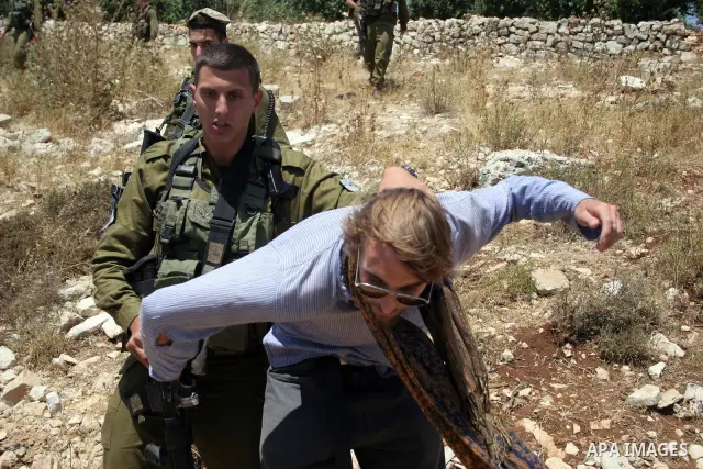 Israeli soldiers detain a foreign activist on Jun 18,2011 during a protest by foreign, Israeli and Palestinian activists against the Jewish settlement of Karmei Tzur near the Palestinian village of Beit Omar, just north...