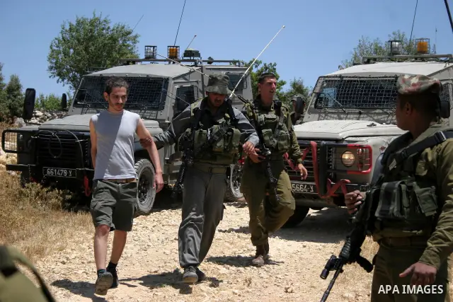 Israeli soldiers detain a foreign activist on Jun 18,2011 during a protest by foreign, Israeli and Palestinian activists against the Jewish settlement of Karmei Tzur near the Palestinian village of Beit Omar, just north...