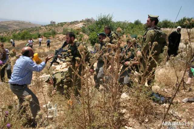 An Israeli soldier falls on the ground during clashes with protesters on Jun 18, 2011 following a demonstration by foreign, Israeli and Palestinian activists against the Jewish settlement of Karmei Tzur near the Palestin...
