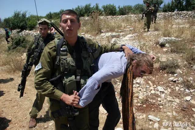 Israeli soldiers detain a foreign activist on Jun 18,2011 during a protest by foreign, Israeli and Palestinian activists against the Jewish settlement of Karmei Tzur near the Palestinian village of Beit Omar, just north...