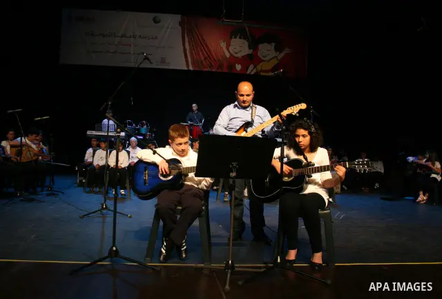 Blind Palestinian children sing and play on the musical instruments during a ceremony in the West Bank city of Ramallah on Jun 18,2011. Photo by Issam Rimawi
