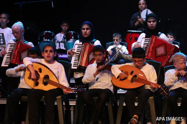 Blind Palestinian children sing and play on the musical instruments during a ceremony in the West Bank city of Ramallah on Jun 18,2011. Photo by Issam Rimawi