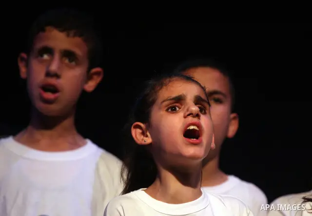 Blind Palestinian children sing and play on the musical instruments during a ceremony in the West Bank city of Ramallah on Jun 18,2011. Photo by Issam Rimawi