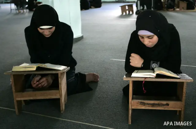 Two Palestinian girls read the Koran at a summer camp for the study of Islam's holy book organised by the Islamist movement Hamas in Rafah in the southern of Gaza Strip on June 19, 2011. Photo by Abed Rahim Khatib