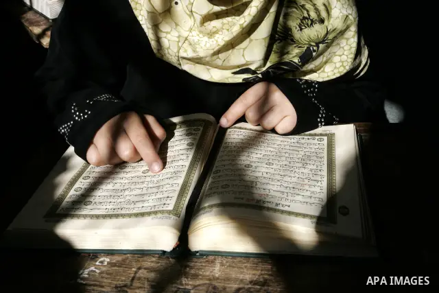 A Palestinian girl reads the Koran at a summer camp for the study of Islam's holy book organised by the Islamist movement Hamas in Rafah in the southern of Gaza Strip on June 19, 2011. Photo by Abed Rahim Khatib