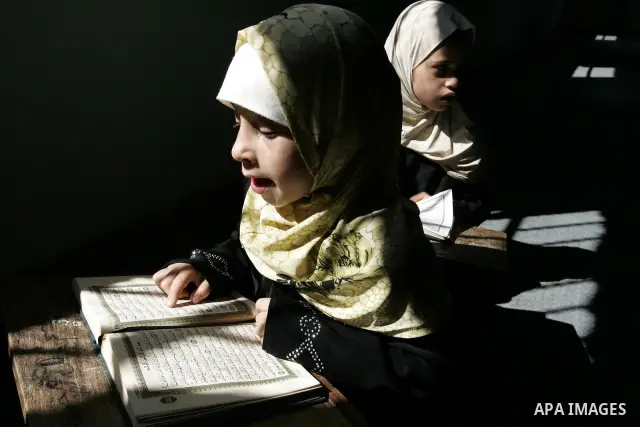 Two Palestinian girls read the Koran at a summer camp for the study of Islam's holy book organised by the Islamist movement Hamas in Rafah in the southern of Gaza Strip on June 19, 2011. Photo by Abed Rahim Khatib