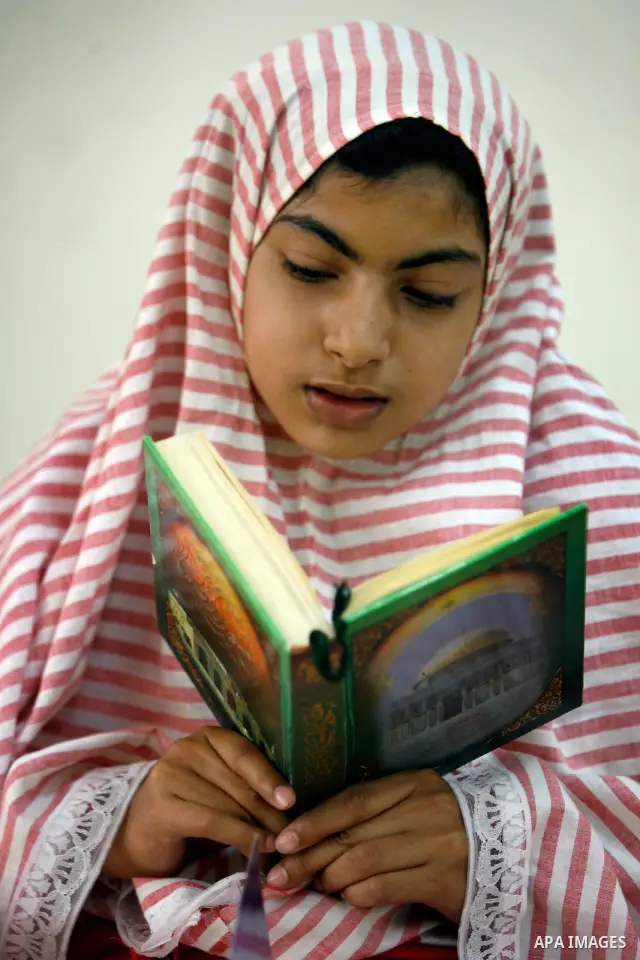 Palestinian girls read the Koran at a summer camp organised by the Islamist movement Hamas in Gaza City, 19 June 2011. About 20,000 students, both male and female, study under the instruction of 1,200 teachers. Hamas usu...