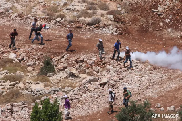 Palestinian protesters clash with Israeli border police officers during minor clashes at a protest against the expansion of a nearby Jewish settlement, in the West Bank village of Deir Qadis, near Ramallah June 19, 2011....