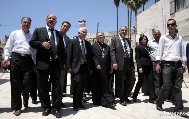The head of the Roman Catholic Church in the Holy Land, the Latin Patriarch of Jerusalem Fuad Twal walks among Palestinian officials near the Ibrahimi Mosque, or Tomb of the Patriarchs, during a visit to the divided West...