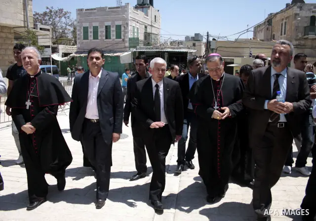 The head of the Roman Catholic Church in the Holy Land, the Latin Patriarch of Jerusalem Fuad Twal walks among Palestinian officials near the Ibrahimi Mosque, or Tomb of the Patriarchs, during a visit to the divided West...