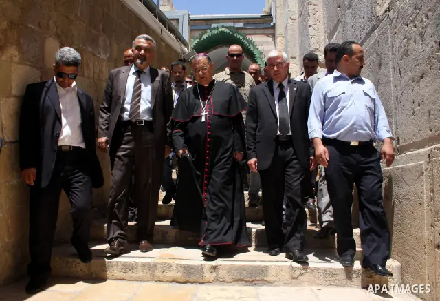 The head of the Roman Catholic Church in the Holy Land, the Latin Patriarch of Jerusalem Fuad Twal walks among Palestinian officials near the Ibrahimi Mosque, or Tomb of the Patriarchs, during a visit to the divided West...