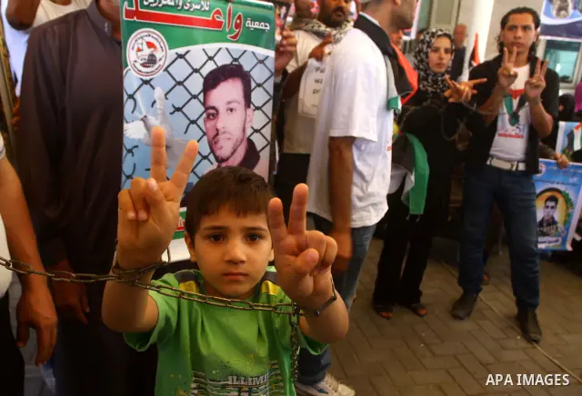 Palestinians hold pictures of their jailed relatives during a protest outside the Red Cross' offices in Gaza City calling for the release of Palestinian prisoners held in Israeli jails, on June 20, 2011. Photo by Ashraf...