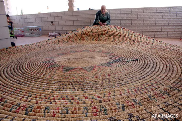Palestinian elderly woman, Raselah Abed Al-Hafez,70 years, hoping to make it into the Guinness Book of Records, prepare what she calls the biggest hay traditional dish in the world in the West Bank city of Ramallah, June...