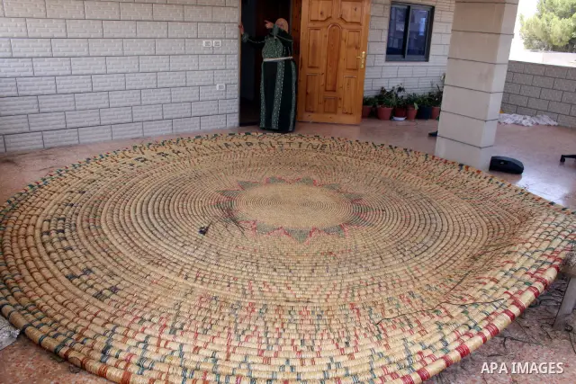 Palestinian elderly woman, Raselah Abed Al-Hafez,70 years, hoping to make it into the Guinness Book of Records, prepare what she calls the biggest hay traditional dish in the world in the West Bank city of Ramallah, June...