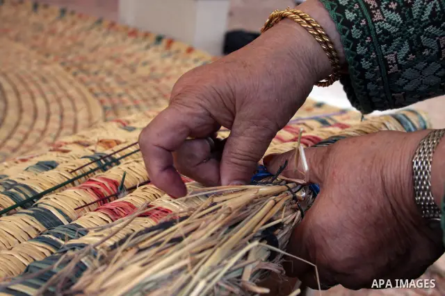 Palestinian elderly woman, Raselah Abed Al-Hafez,70 years, hoping to make it into the Guinness Book of Records, prepare what she calls the biggest hay traditional dish in the world in the West Bank city of Ramallah, June...