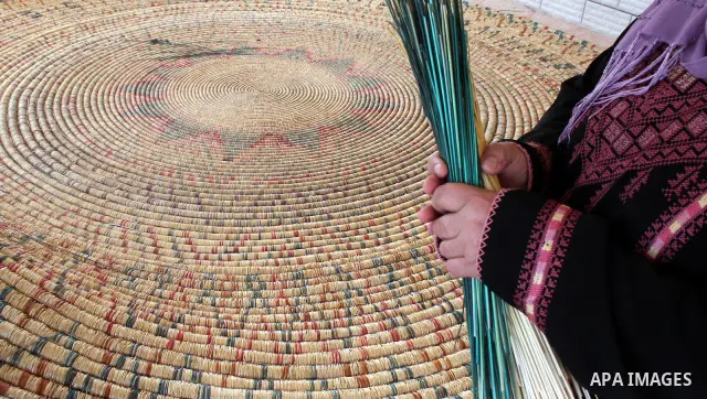 Palestinian elderly woman, Raselah Abed Al-Hafez,70 years, hoping to make it into the Guinness Book of Records, prepare what she calls the biggest hay traditional dish in the world in the West Bank city of Ramallah, June...
