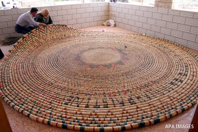 Palestinian elderly woman, Raselah Abed Al-Hafez,70 years, hoping to make it into the Guinness Book of Records, prepare what she calls the biggest hay traditional dish in the world in the West Bank city of Ramallah, June...