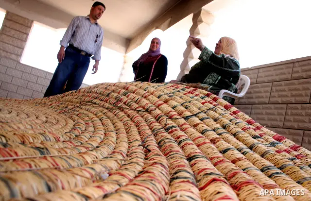 Palestinian elderly woman, Raselah Abed Al-Hafez,70 years, hoping to make it into the Guinness Book of Records, prepare what she calls the biggest hay traditional dish in the world in the West Bank city of Ramallah, June...