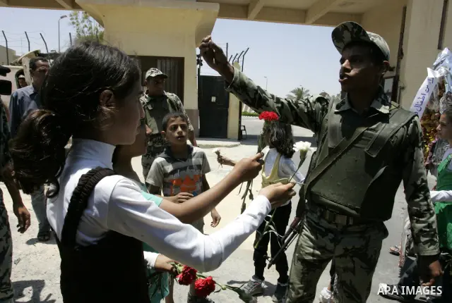 Palestinian children hand out flowers to Egyptian soldiers during a rally in front of the Rafah border crossing with Egypt in the southern Gaza Strip on June 21, 2011, demanding it to be open permanently and without rest...