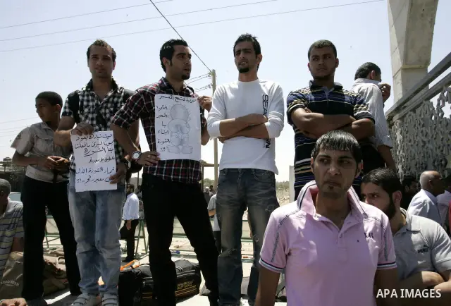 Palestinians wait to cross the Rafah border crossing with Egypt, in the southern Gaza Strip, on June 21, 2011. Demonstrators gathered at the crossing demanding it to be open permanently and without restrictions or condit...