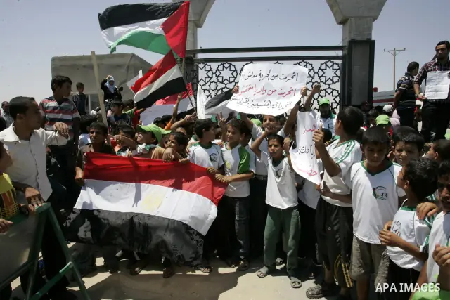 Palestinian children hold banners and Egyptian flag during a rally in front of the Rafah border crossing with Egypt in the southern Gaza Strip on June 21, 2011, demanding it to be open permanently and without restriction...