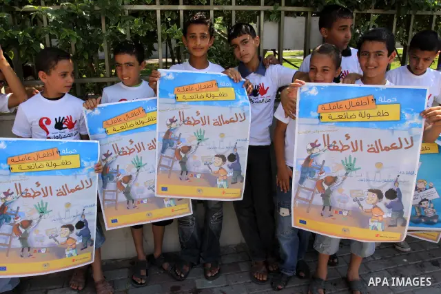 Palestinian children hold up signs during a protest against child labor in Gaza city on June 22, 2011. this protest under the auspices of Save the Children and heading to the Ministry of Labour. Photo by Mohammed Asad