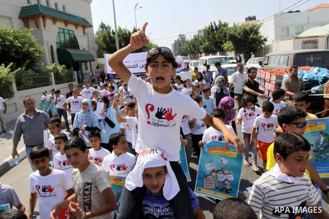 Palestinian children hold up signs during a protest against child labor in Gaza city on June 22, 2011. this protest under the auspices of Save the Children and heading to the Ministry of Labour. Photo by Mohammed Asad