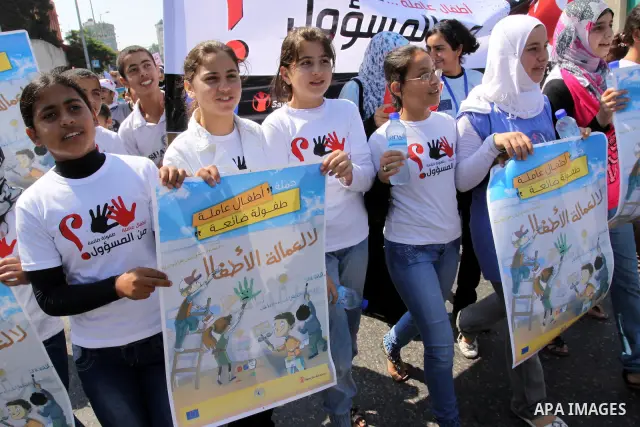 Palestinian children hold up signs during a protest against child labor in Gaza city on June 22, 2011. this protest under the auspices of Save the Children and heading to the Ministry of Labour. Photo by Mohammed Asad