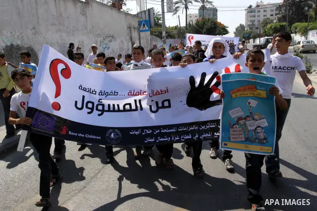 Palestinian children hold up signs during a protest against child labor in Gaza city on June 22, 2011. this protest under the auspices of Save the Children and heading to the Ministry of Labour. Photo by Mohammed Asad