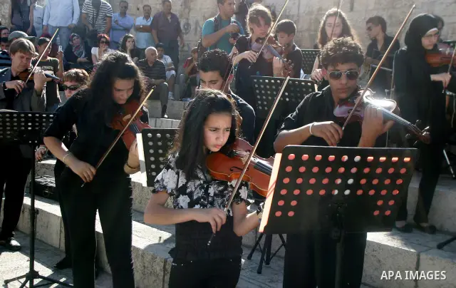 Palestinians and foreigners play the violin in front of the Damascus Gate in Jerusalem's old city on Jun 22,2011. Photo by Mahfouz Abu Turk