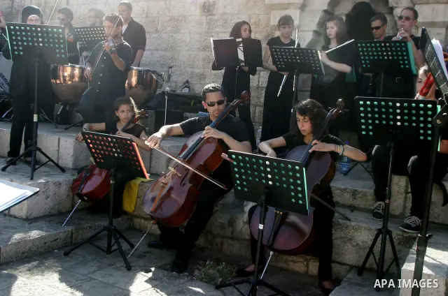 Palestinians and foreigners play the violin in front of the Damascus Gate in Jerusalem's old city on Jun 22,2011. Photo by Mahfouz Abu Turk