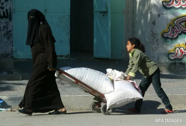 A veiled Palestinian woman pulls sacks of flour in Rafah, southern Gaz Strip on June 22,2011. Photo by Abed Rahim Khatib