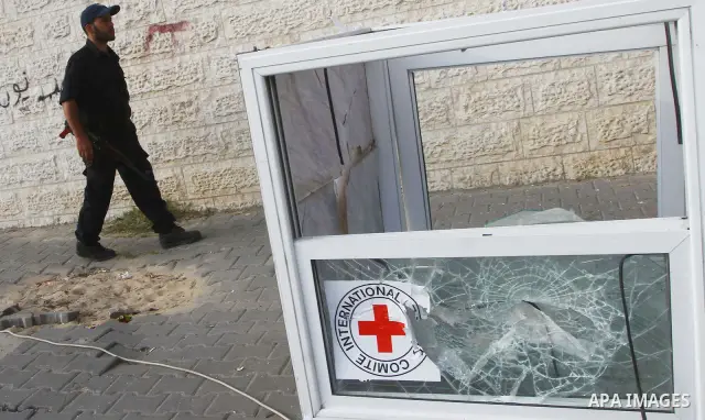 A Palestinian policeman guards outside the building housing the offices of the International Committee of the Red Cross (ICRC) as dozens of angry protesters demonstrated outside the premises of the ICRC in Gaza City on J...