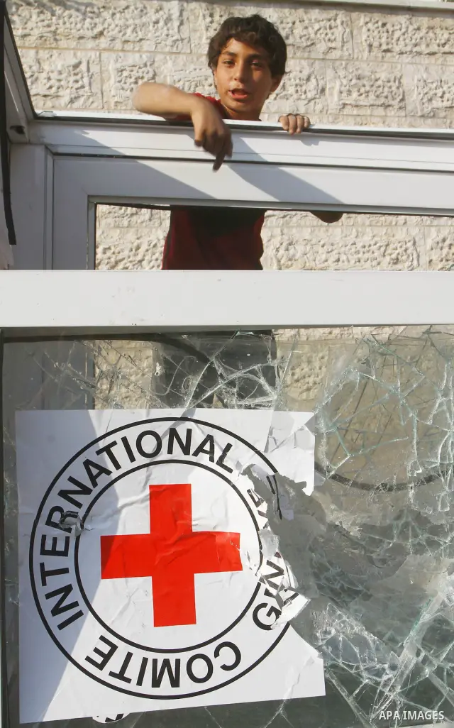 A Palestinian boy destroys the guard post outside the building housing the offices of the International Committee of the Red Cross (ICRC) as dozens of angry protesters demonstrated outside the premises of the ICRC in Gaz...