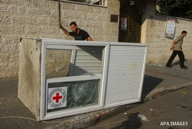 A Palestinian man destroys the guard post outside the building housing the offices of the International Committee of the Red Cross (ICRC) as dozens of angry protesters demonstrated outside the premises of the ICRC in Gaz...