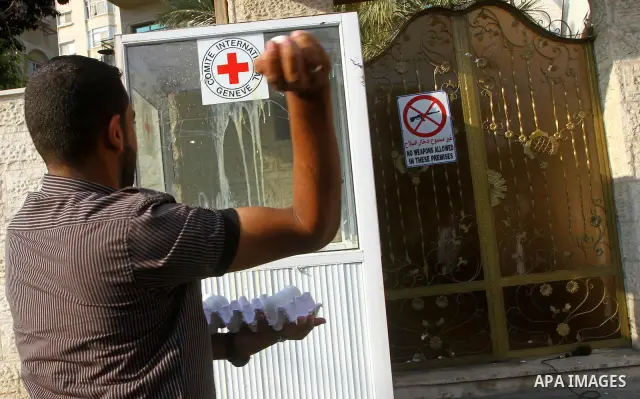A Palestinian man throws eggs at the buidling housing the offices of the International Committee of the Red Cross (ICRC) as dozens of angry protesters demonstrated outside the premises of the ICRC in Gaza City on June 23...