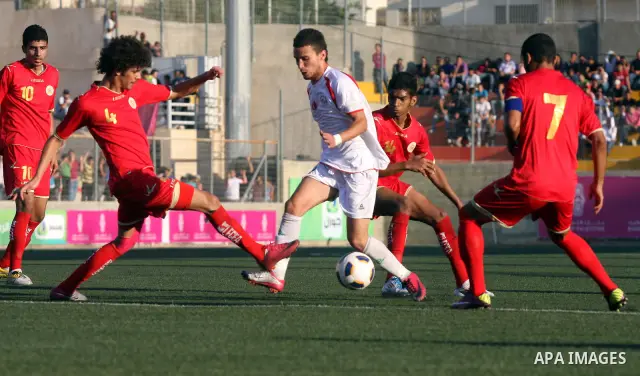 Palestinian team's player challenges the Bahrain's player during their 2012 Olympic qualifying football match in the West Bank town of Al-Ram, near Ramallah, on June 23, 2011 . Photo by Issam Rimawi
