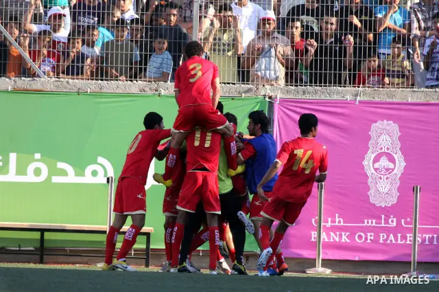 Bahraini national team players celebrate after scoring a goal against the Palestinian team during their 2012 Olympic qualifying football match in the West Bank town of Al-Ram, near Ramallah, on June 23, 2011. Photo by Is...