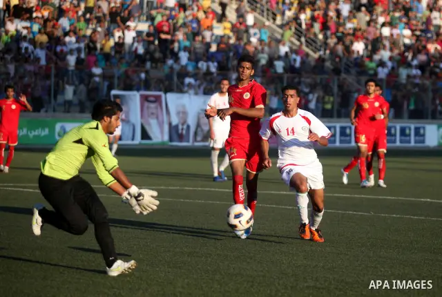 Palestinian team's player challenges the Bahrain's player during their 2012 Olympic qualifying football match in the West Bank town of Al-Ram, near Ramallah, on June 23, 2011 . Photo by Issam Rimawi