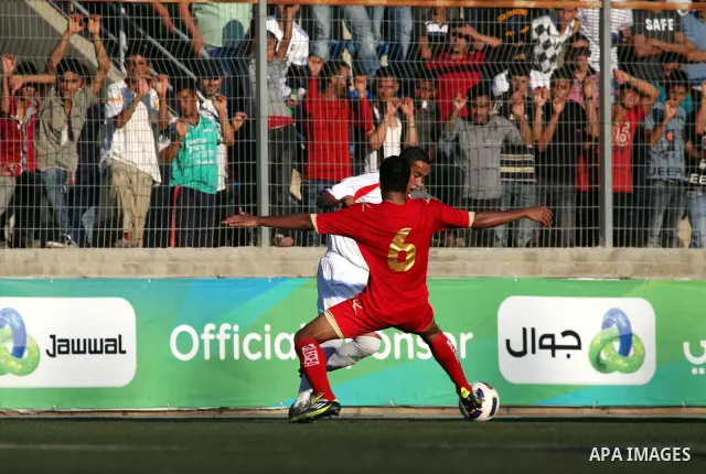 Palestinian team's player challenges the Bahrain's player during their 2012 Olympic qualifying football match in the West Bank town of Al-Ram, near Ramallah, on June 23, 2011 . Photo by Issam Rimawi