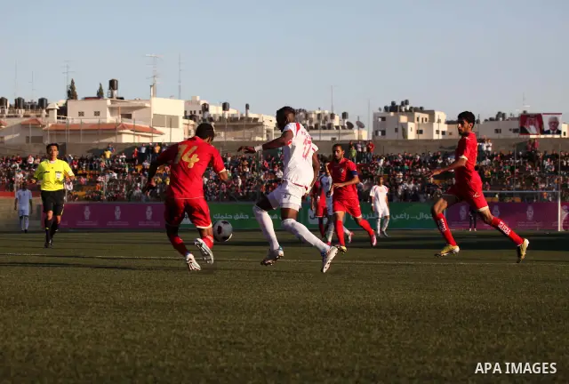 Palestinian team's player challenges the Bahrain's player during their 2012 Olympic qualifying football match in the West Bank town of Al-Ram, near Ramallah, on June 23, 2011 . Photo by Issam Rimawi