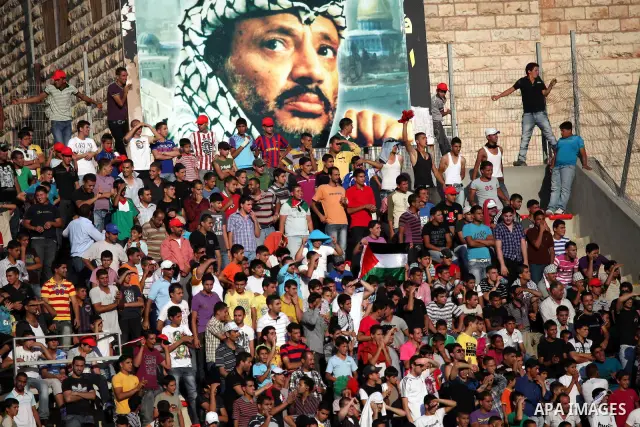 Palestinian fans attend a football match between their national team and Bahrain team during their 2012 Olympic qualifying football match in the West Bank town of Al-Ram, near Ramallah, on June 23, 2011. Photo by Issam R...