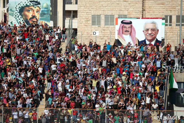Palestinian fans attend a football match between their national team and Bahrain team during their 2012 Olympic qualifying football match in the West Bank town of Al-Ram, near Ramallah, on June 23, 2011. Photo by Issam R...