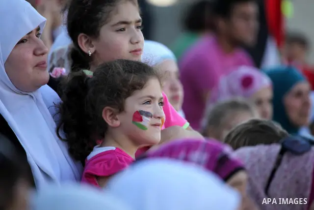Palestinian fans attend a football match between their national team and Bahrain team during their 2012 Olympic qualifying football match in the West Bank town of Al-Ram, near Ramallah, on June 23, 2011. Photo by Issam R...