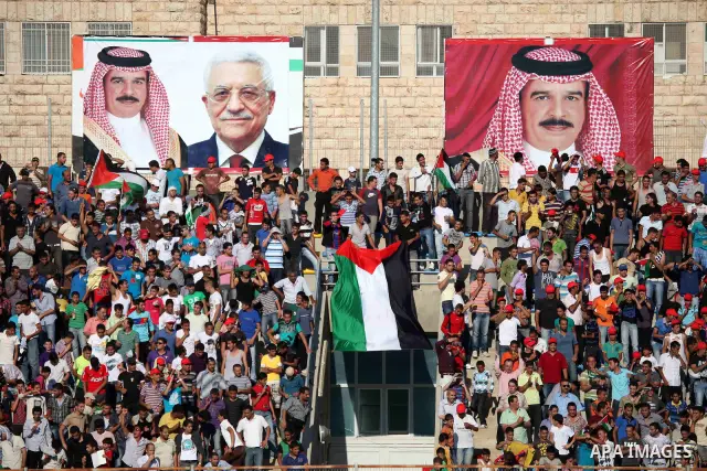 Palestinian fans attend a football match between their national team and Bahrain team during their 2012 Olympic qualifying football match in the West Bank town of Al-Ram, near Ramallah, on June 23, 2011. Photo by Issam R...