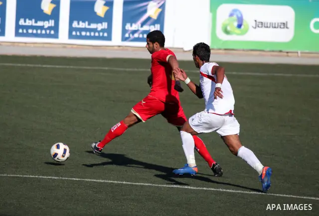 Palestinian team's player challenges the Bahrain's player during their 2012 Olympic qualifying football match in the West Bank town of Al-Ram, near Ramallah, on June 23, 2011 . Photo by Issam Rimawi